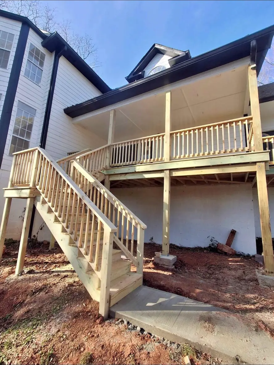 Elevated pressure-treated deck with a long staircase and wood railings